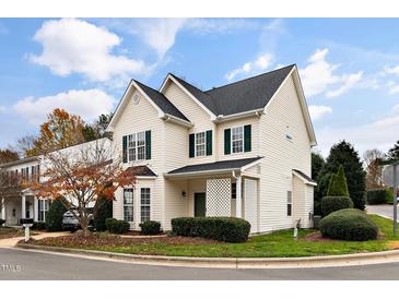 Charming two-story home featuring green shutters, well-manicured landscaping and a beautiful tree in the front yard at 2014 Silky Dogwood Trl, Apex, NC 27502
