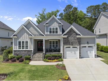 Charming home with stone accents, a two-car garage, covered porch, and well-manicured lawn at 2086 Amalfi Pl, Apex, NC 27502