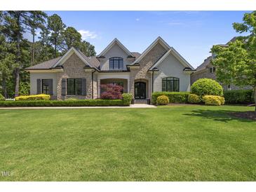 Beautiful two-story home featuring stone accents, lush landscaping, and a well-manicured lawn at 209 Preston Retreat Ln, Cary, NC 27513