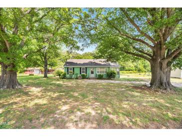 Charming, single-story home with a green exterior and mature trees in a tranquil setting at 2677 Nc-39, Henderson, NC 27537