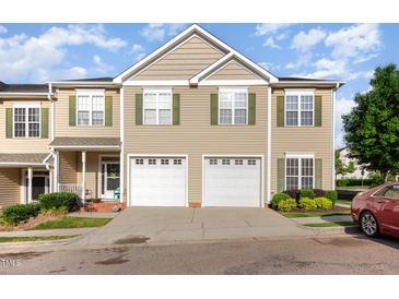 Charming townhome featuring two-car garage, green shutters, and well-maintained landscaping at 300 Sugar Maple Ave, Wake Forest, NC 27587