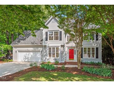Charming two-story home with a well-manicured lawn and a bright red front door at 4900 American Dr, Durham, NC 27705