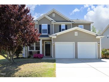 Charming two-story home with a manicured lawn and attached two-car garage at 621 Childsberg Way, Hillsborough, NC 27278