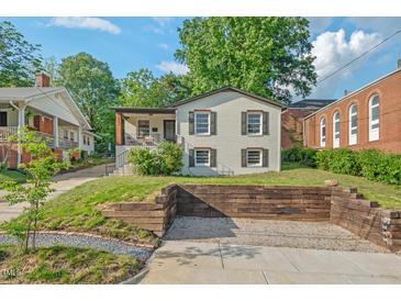 Charming home featuring white painted brick, dark shutters, a cozy front porch, and ample parking at 623 Massey Ave, Durham, NC 27701