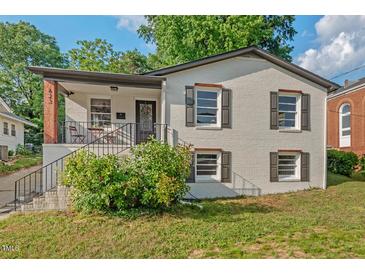 Charming white brick home featuring a cozy front porch and well-maintained yard at 623 Massey Ave, Durham, NC 27701
