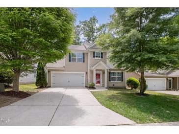 Charming two-story home with a manicured lawn, a two-car garage, and a welcoming red front door at 809 Amarillo Rose Ln, Durham, NC 27712