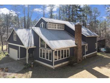 Stunning home exterior with unique architectural details, many windows and a stone chimney at 1000 Phils Creek Rd, Chapel Hill, NC 27516