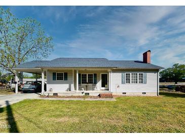 Charming single-story home featuring a carport, covered front porch, light siding and green shutters at 107 N Pearl St, Princeton, NC 27569