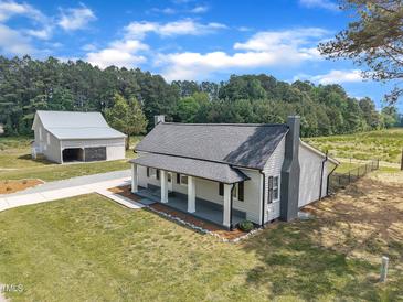 Charming home with a front porch, detached garage, and a well-manicured lawn at 1347 Crocker Rd, Smithfield, NC 27577