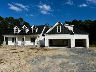 Charming new construction home with a three-car garage, white siding, and a welcoming front porch at 196 Cozy Brook Ct, Clayton, NC 27520