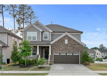 Charming two-story home featuring stone accents, gray siding, and a two-car garage at 232 Kanewind Ter, Apex, NC 27523
