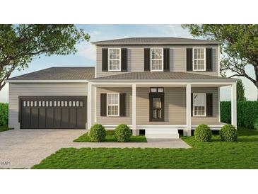 Charming two-story home featuring a covered front porch, a two car garage and manicured landscaping at 337 Green Pines Estates Dr, Kenly, NC 27542