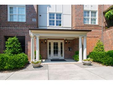 Welcoming brick building entrance with white columns, double doors, and manicured landscaping at 340 Allister Dr # 201, Raleigh, NC 27609