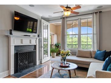 Inviting living room with fireplace, hardwood floors, and french doors to the balcony at 340 Allister Dr # 201, Raleigh, NC 27609