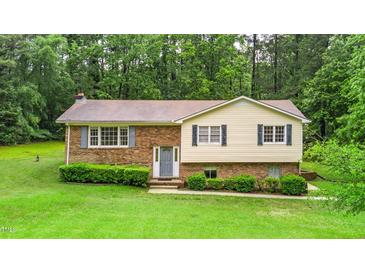 Charming split-level home with a brick facade and manicured lawn surrounded by mature trees at 4006 Daniel Rd, Durham, NC 27703