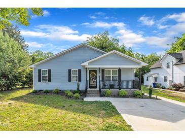 Charming home featuring a welcoming front porch, fresh landscaping, and a well-manicured lawn at 407 Collier St, Smithfield, NC 27577