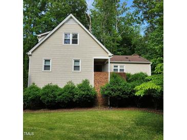 Charming two-story home with beige siding, brick accents, and a beautifully landscaped front yard with mature trees at 4900 North Hills Dr, Raleigh, NC 27612