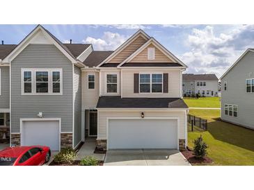 Charming two-story home featuring a light beige exterior, attached garage, and well-maintained landscaping at 5054 Kota St, Raleigh, NC 27610