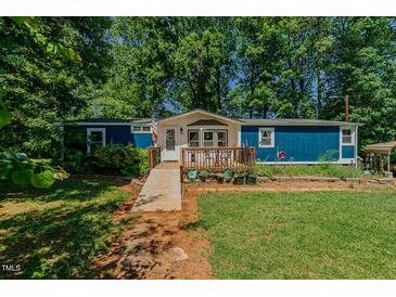 Charming blue single-story home with a wooden ramp leading to the front deck at 5100 Yale Ct, Graham, NC 27253