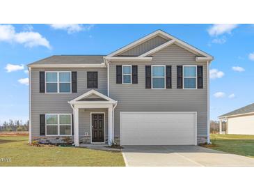 Two story home with gray siding, a two-car garage and a well-manicured lawn at 511 Lochalsh Dr, Gibsonville, NC 27249