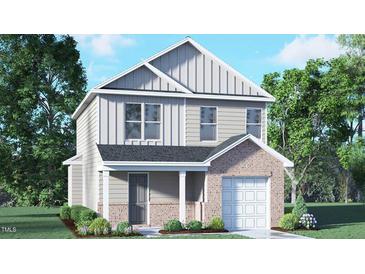 Charming two-story home with gray siding, brick accents, covered entry, and attached garage at 6036 Sodium St, Raleigh, NC 27610