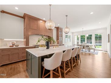 Bright, spacious kitchen features a large island with marble countertops and seating for four at 909 N Gregson St, Durham, NC 27701