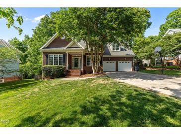Charming brick home featuring a well-manicured lawn and a two-car garage with basketball goal at 104 Crossway Ln, Holly Springs, NC 27540