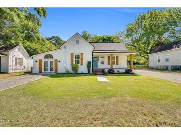 Charming white home with inviting curb appeal, featuring a manicured lawn and contrasting wood accents at 105 N 11Th St, Erwin, NC 28339