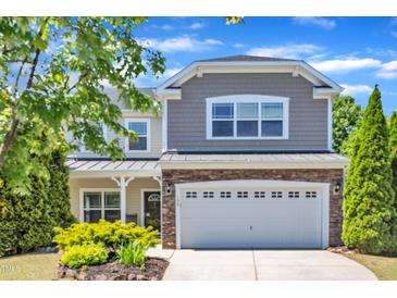 Charming two-story home features a stone facade and well-manicured landscaping, enhancing curb appeal at 120 Cobblebrook Ct, Holly Springs, NC 27540