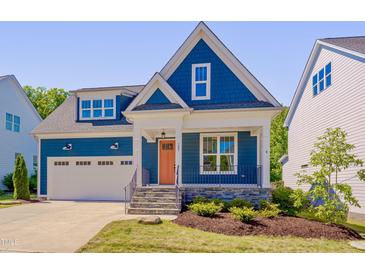Charming two-story home featuring a blue exterior, stone accents, an orange front door and an attached garage at , Chapel Hill, NC 27516
