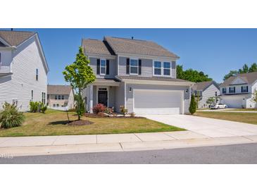 Charming two-story home with a well-manicured lawn, a two-car garage, and beautiful landscaping at 147 Antler Steel Dr, Clayton, NC 27527