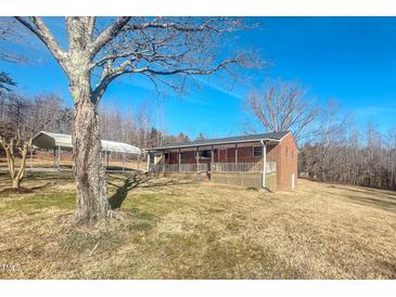 Charming brick home with covered porch, carport, and mature trees on a sunny day at 178 Medford Oakley Rd, Rougemont, NC 27572