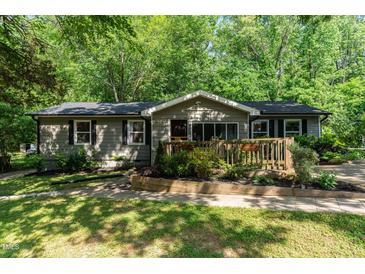 Charming single story home with a welcoming entrance surrounded by lush landscaping and mature trees at 2029 Atkins Dr, Raleigh, NC 27610