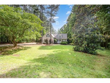 Charming home featuring a spacious lawn with mature trees and manicured landscaping at 25 Williamston Ridge Dr, Youngsville, NC 27596