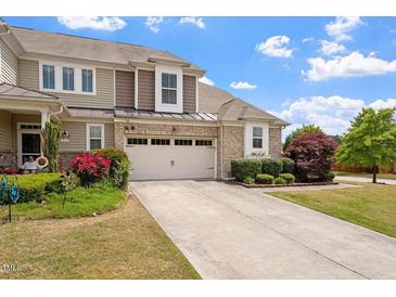 Charming two-story home boasts a well-manicured lawn and inviting curb appeal with blooming flowers at 2737 Casper Creek Ln, Raleigh, NC 27616