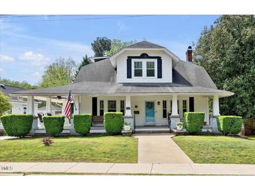 Charming home with a covered front porch, manicured lawn, and classic architectural details at 310 Henderson St, Oxford, NC 27565