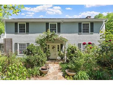 Charming two-story home with mature landscaping and a welcoming stone walkway to the front door at 400 Bowling Creek Rd, Chapel Hill, NC 27514