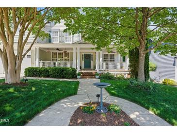 Charming home featuring a welcoming front porch, lush lawn, and mature trees at 415 Waverly Hills Dr, Cary, NC 27519