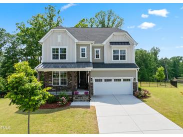 Charming two-story home featuring stone accents, a covered porch, a well-manicured lawn, and an attached two-car garage at 46 Waterfall Pointe, Chapel Hill, NC 27517