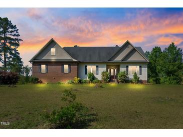 Charming home featuring brick and vinyl siding, complemented by a well-maintained lawn, showcasing classic design elements at 494 Asset Pkwy, Sanford, NC 27332