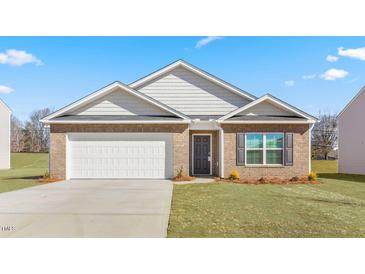 Charming brick home with an attached garage, manicured lawn, and lovely landscaping at 505 Lochalsh Dr, Gibsonville, NC 27249