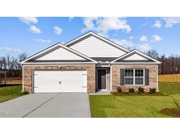Charming single-story brick home with a two-car garage and well-maintained front lawn at 517 Lochalsh Dr, Gibsonville, NC 27249