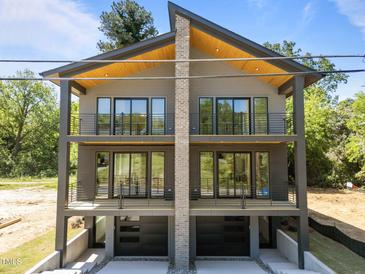 Modern three-story home featuring two levels of balconies and a unique central chimney design at 528 Bragg St, Raleigh, NC 27610