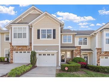 Charming townhome with a well-manicured lawn, attached garage, and beautiful landscaping at 5912 Hourglass Ct, Raleigh, NC 27612