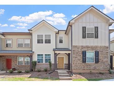 Charming townhome featuring neutral siding, brick accents, and a covered front porch at 709 Wickham Ridge Rd, Apex, NC 27539