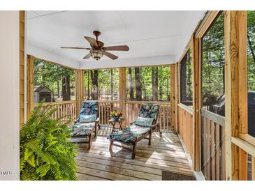 A relaxing screened-in porch with lounge chairs offering views of a wooded backyard at 11 Bridgeport Dr, Durham, NC 27713