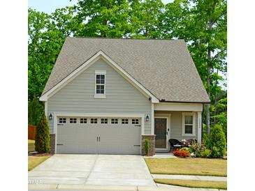 Charming home featuring a two-car garage, complemented by manicured landscaping and a welcoming front porch at 12404 Huntley Chase Dr, Durham, NC 27703