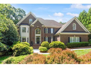 Beautiful brick home featuring a manicured lawn and mature landscaping for great curb appeal at 1312 Glenden Falls Way, Raleigh, NC 27614