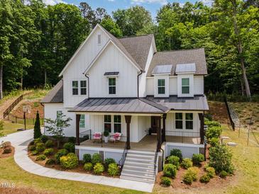 Charming two-story home featuring a covered porch, manicured landscaping, and modern white siding at 1344 Legend Oaks Drive Dr, Chapel Hill, NC 27517