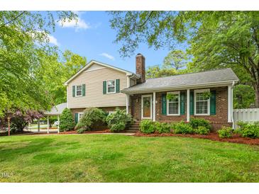 Charming two-story home featuring a brick facade, green shutters, and a well-manicured lawn at 204 Random Ln, Burlington, NC 27215